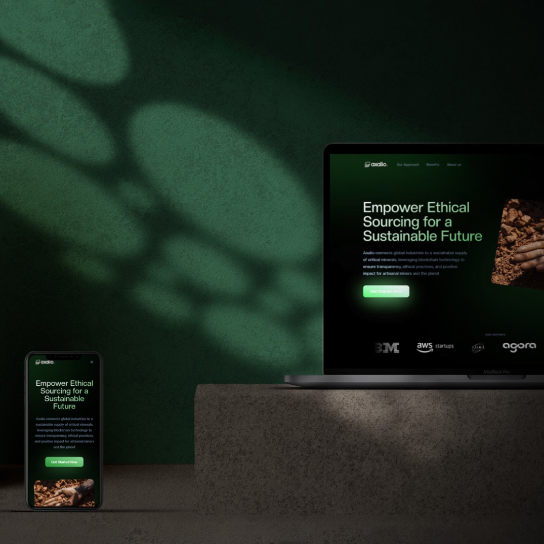 Laptop and phone mockup on a stone plinth against a green wall, both showing the Axalio hero
